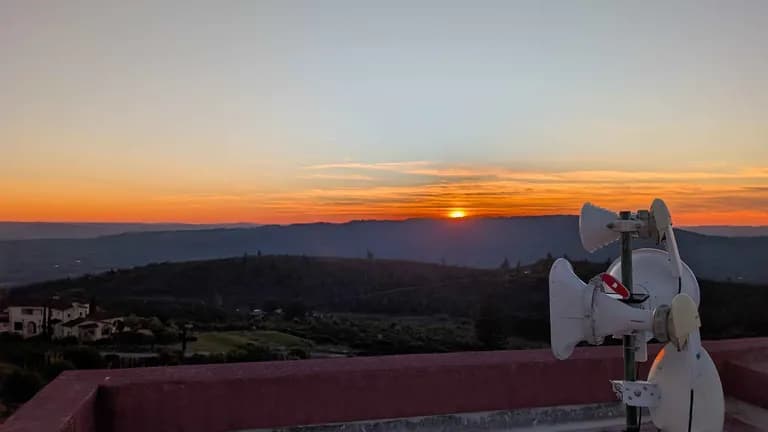 Sonoma sunset over layered ridgelines with a Trellis dish array in the right foreground.